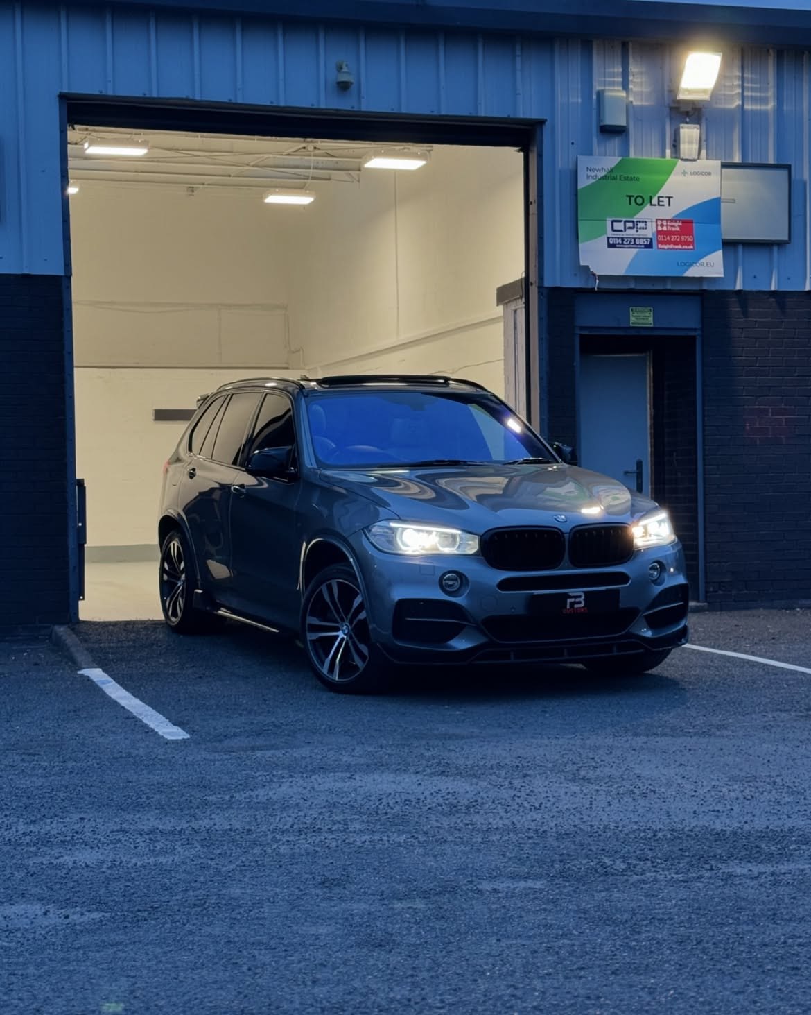 Blue BMW X5 outside the FB CUSTOMS workshop