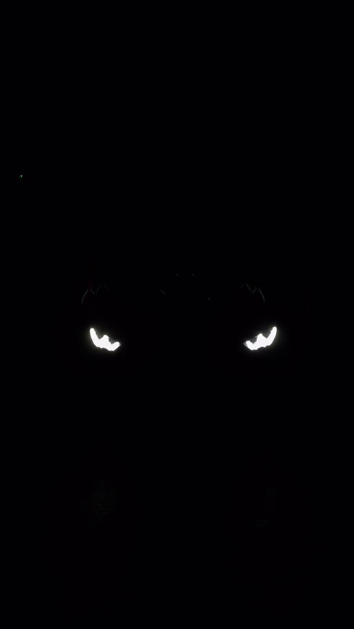 Two bright vehicle headlights in darkness